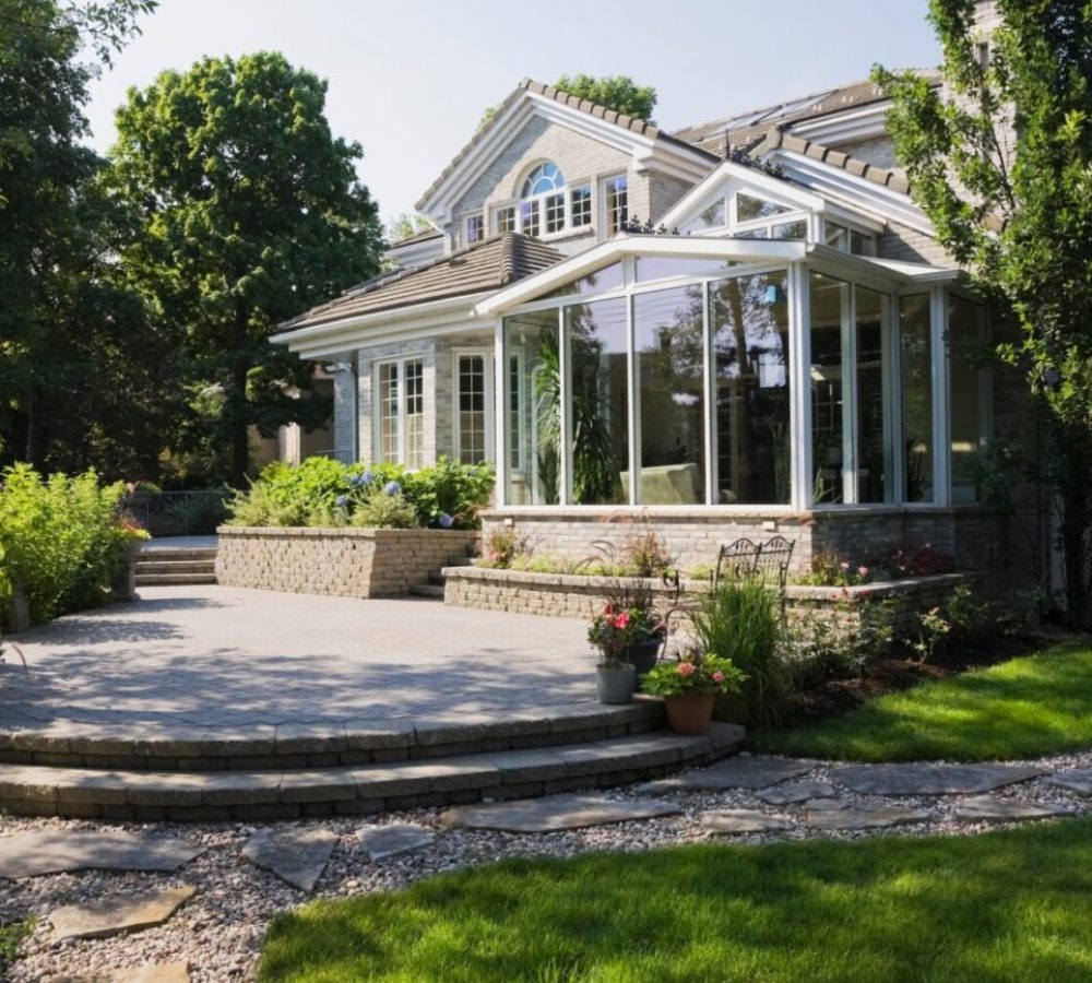 Brick and stone cottage style home with sunroom, patio and landscaped backyard, Quebec, Canada