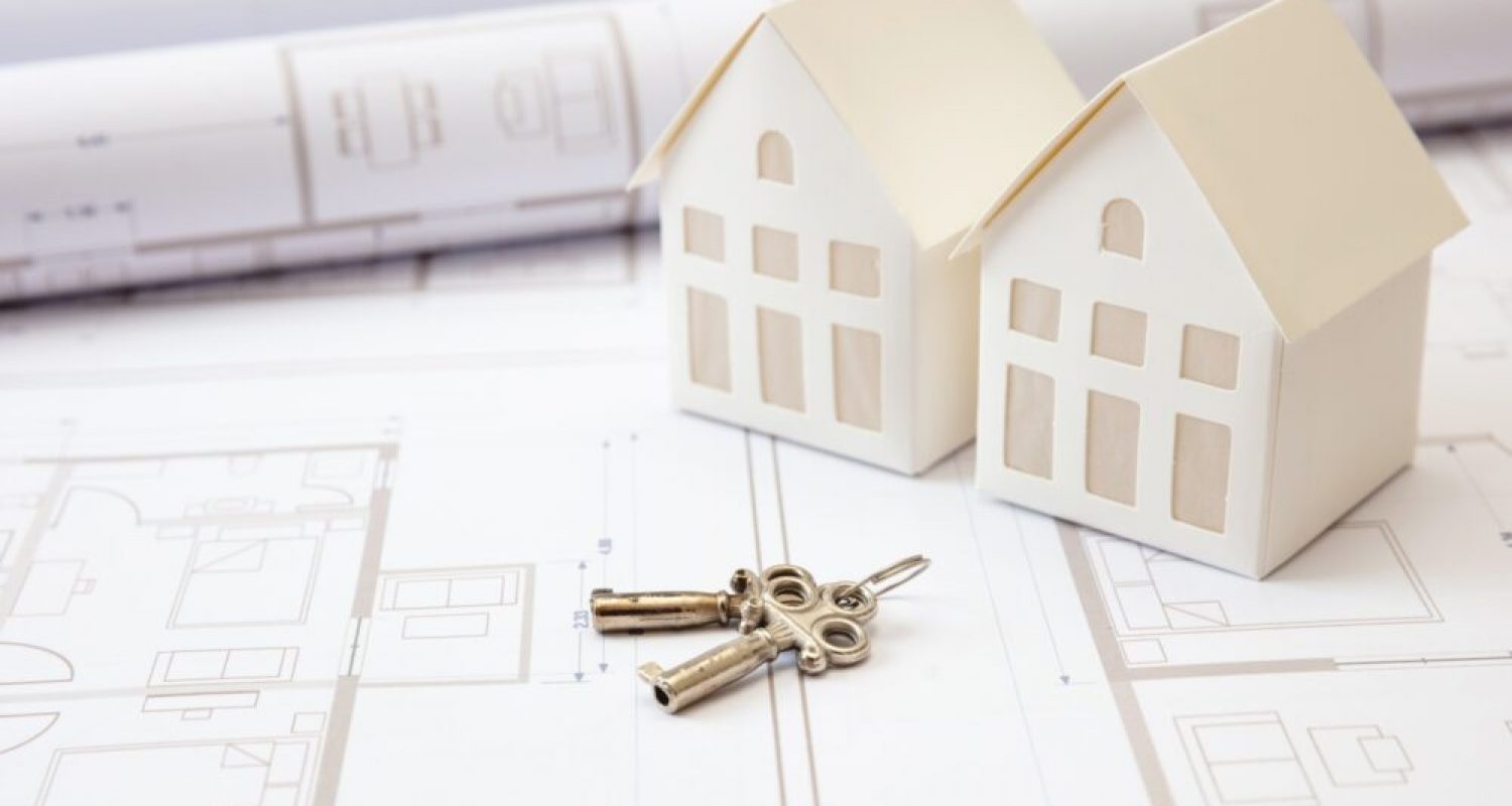 Construction concept. Residential building drawings and house keys on an office desk